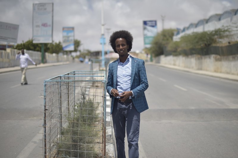 Mohamed Hussein Hassan, Chairman of City Flowers, next to one of the trees planted by his organization in Mogadishu. Their projects include city clean-ups, planting trees along the capital’s roads, and painting cross walks at busy intersections.