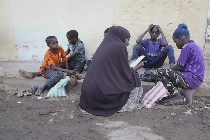 Jamila Haji Mohamed (centre), Chairwoman of the Mis-Hurty Arlaathey organization, takes the contact information of children living on the streets of Baidoa, Somalia. Jamila has helped enroll street children in formal schools.