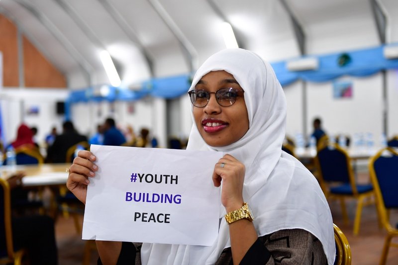 A Somali youth holds a peace message at a ceremony to mark International Youth Day, held in Mogadishu on August 12, 2017. Somali youths have become proactive in peace-building initiatives in various parts of the country.