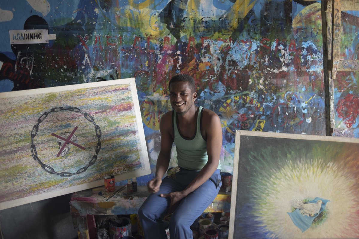 Abdiwahab Hassan Omar, a Cofounder of Aqiila Art Group, sits next to some of his paintings at his studio in Mogadishu. The group of painters and artists that Abdiwahab belongs to is helping to beautify Mogadishu by painting the city’s defensive barriers i